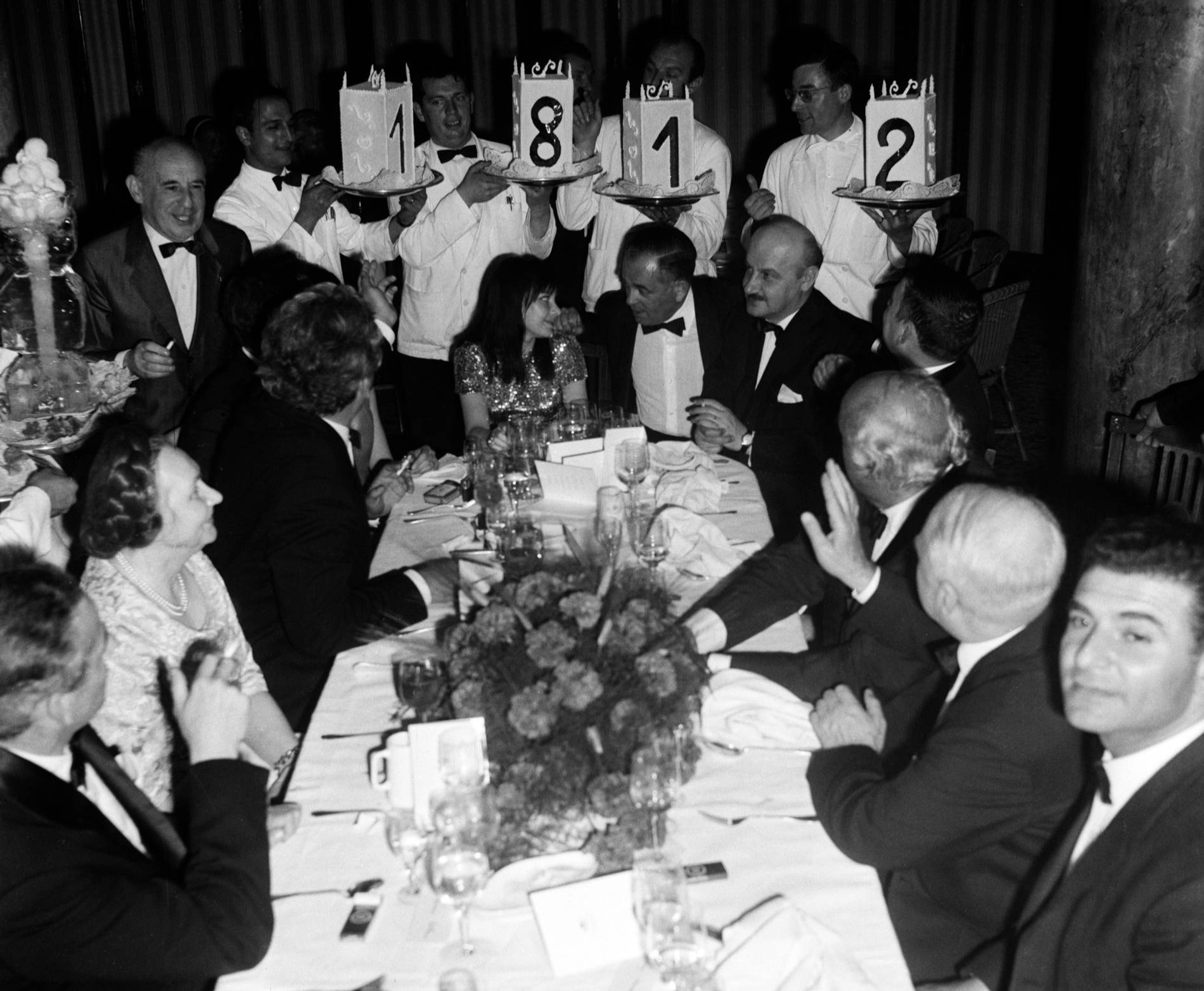 Вечеринка после показа «Войны и мира». В центре стола — Людмила Савельева, за ней — официанты с блюдом «1812»