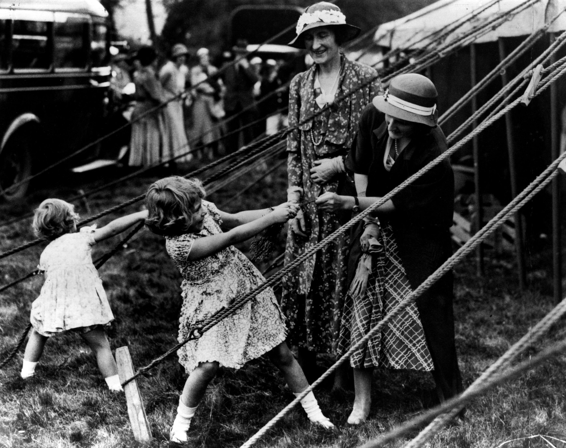 Принцессы Елизавета и Маргарет играют на ярмарке в Шотландии.