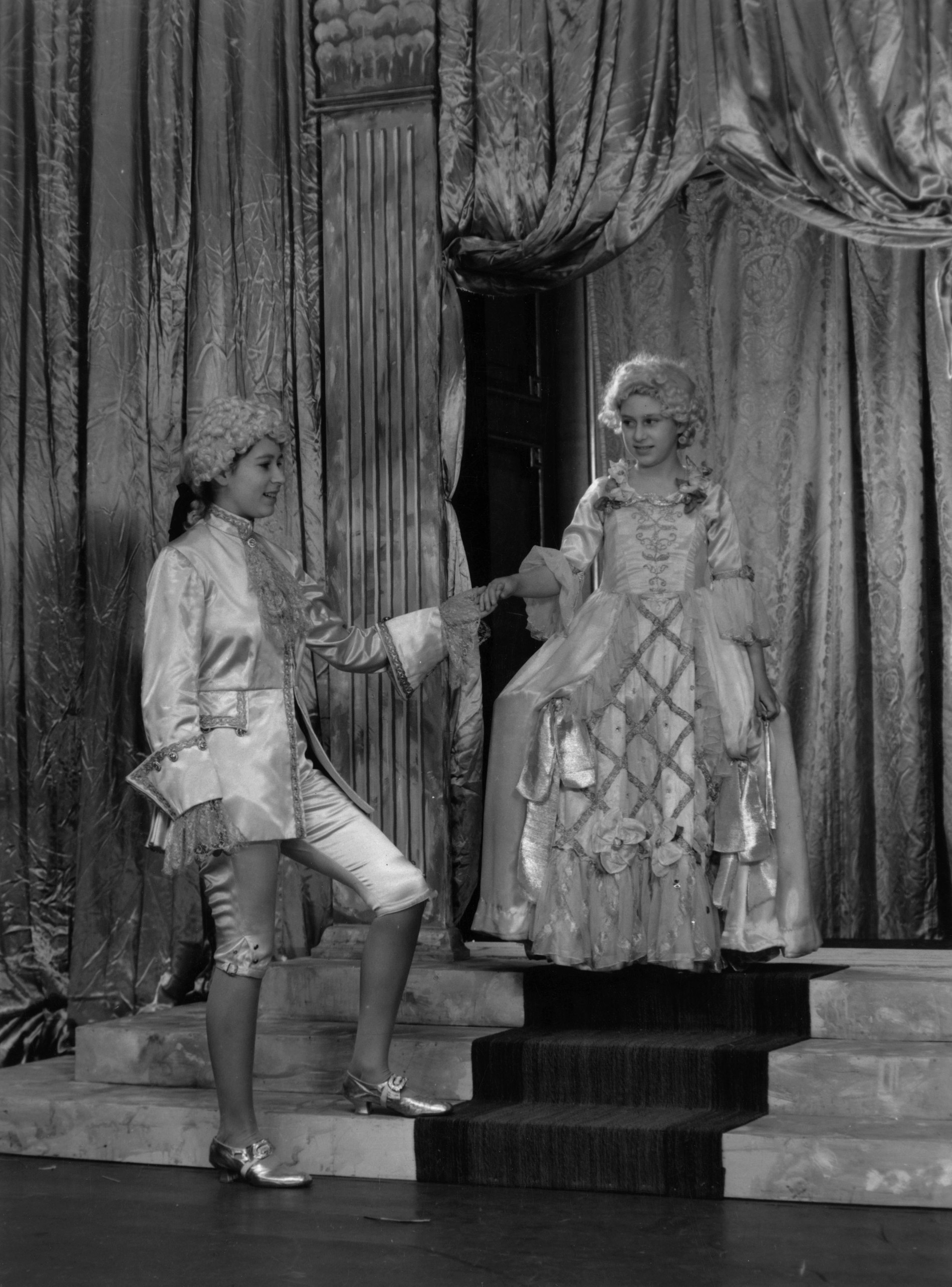 Принцесса Елизавета в роли принца Чарминга и принцесса Маргарет в роли Золушки репетируют спектакль в Виндзорском замке.