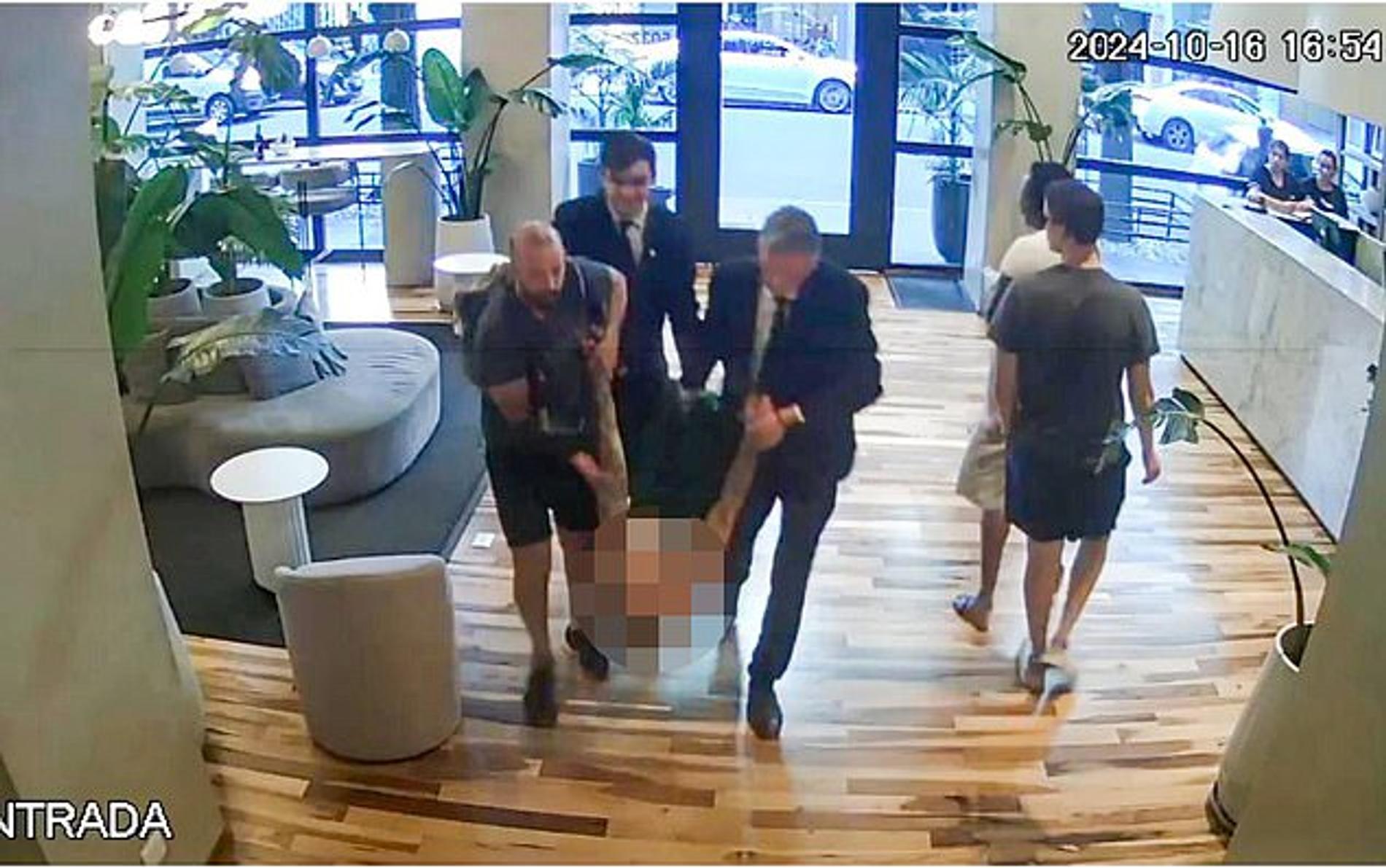 Сотрудники отеля ведут Лиама Пейна в номер. Фото: Daily Mail